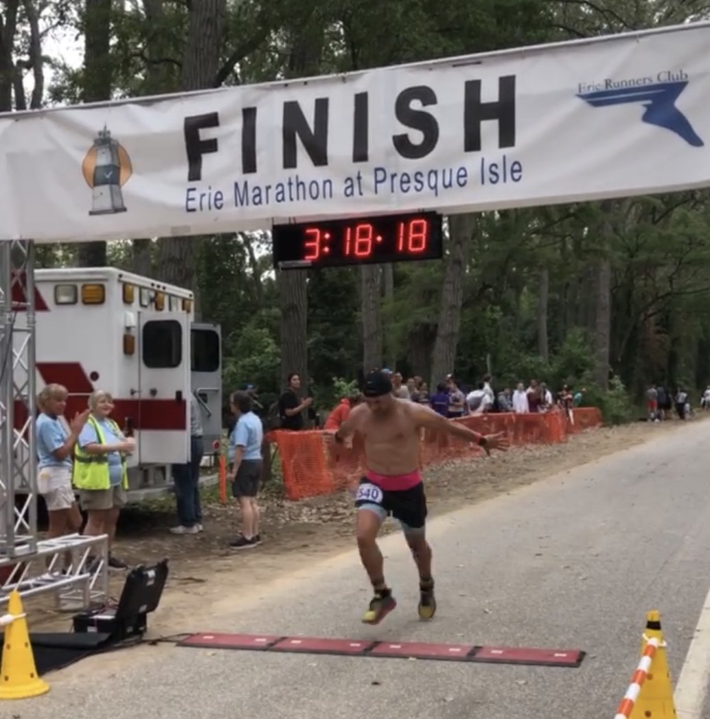 running man crossing marathon finish line